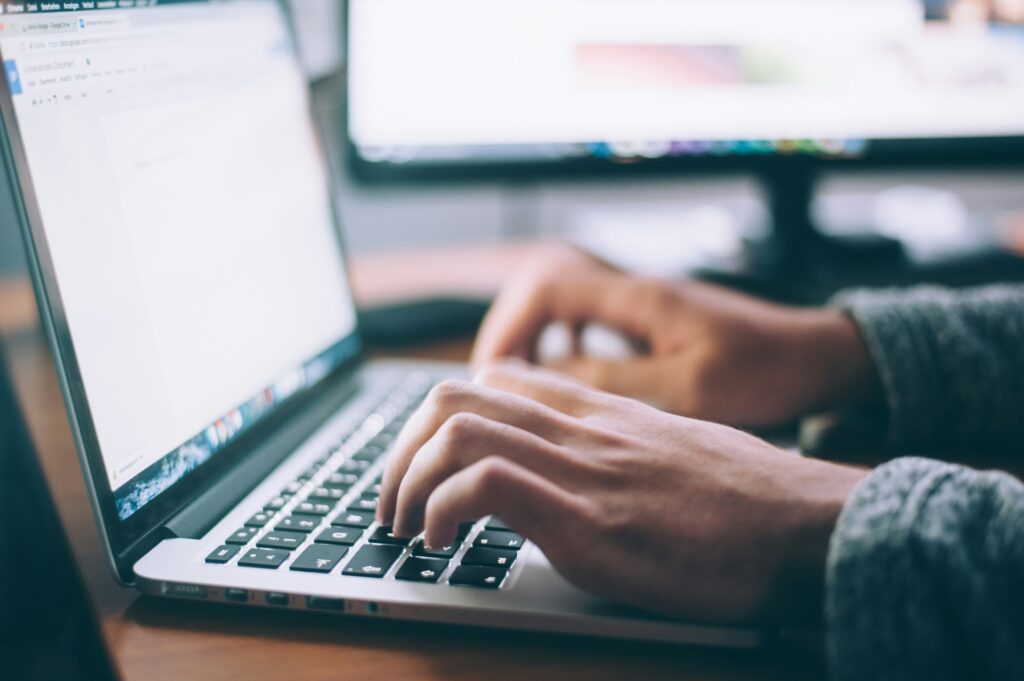 Close up of a person's hands typing on laptop